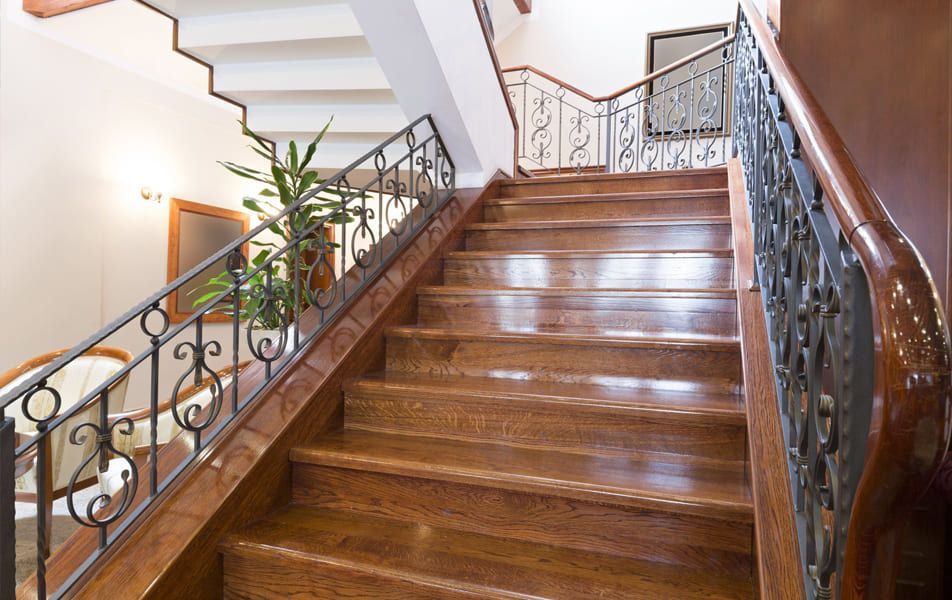 Escalier en bois avec rampes en fer forgé ornées dans un intérieur lumineux