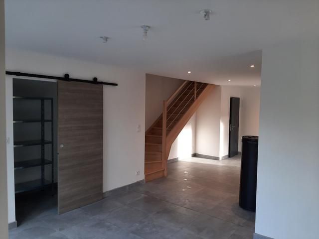 Intérieur moderne vide avec porte coulissante de style grange, escalier et sol carrelé