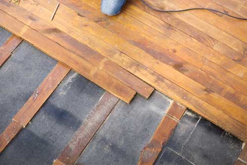 Des planches de toiture en bois sont installées sur une membrane d'étanchéité foncée avec des liteaux apparents.