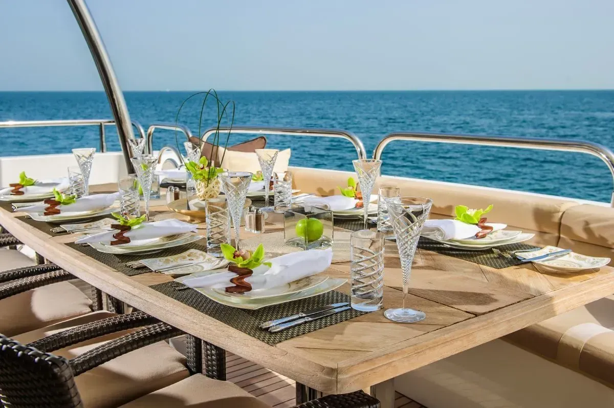 A table set for dining on a yacht overlooking the ocean.