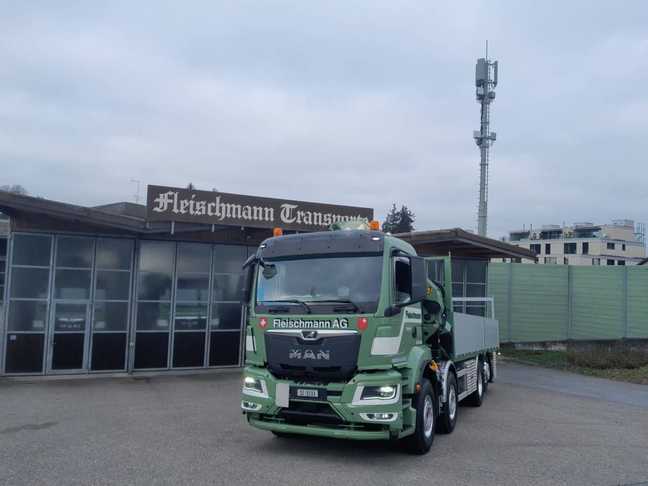Green MAN truck in front of 