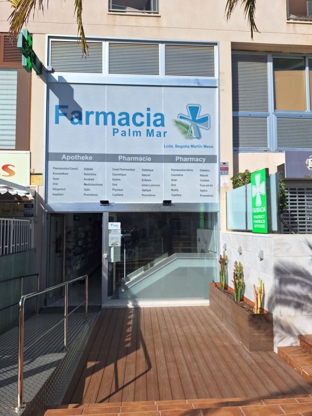 Entrada a Farmacia Palm Mar con letrero azul y pasarela con rampa.