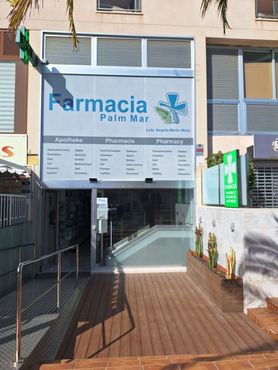 Entrada a Farmacia Palm Mar con letrero azul y pasarela con rampa.