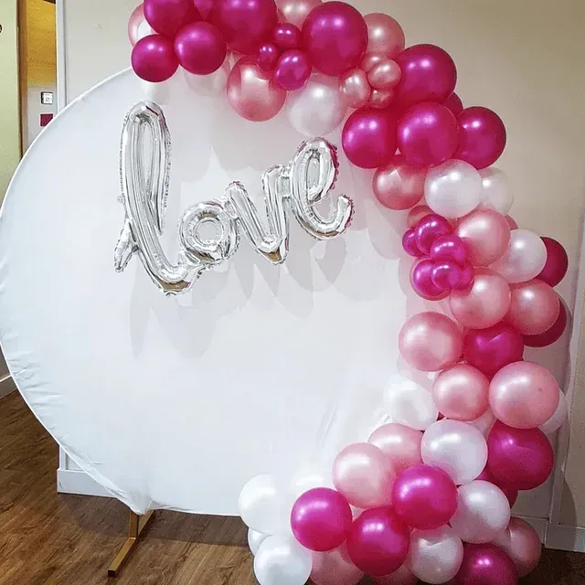Un globo con la palabra amor está rodeado de globos rosados ​​y blancos.