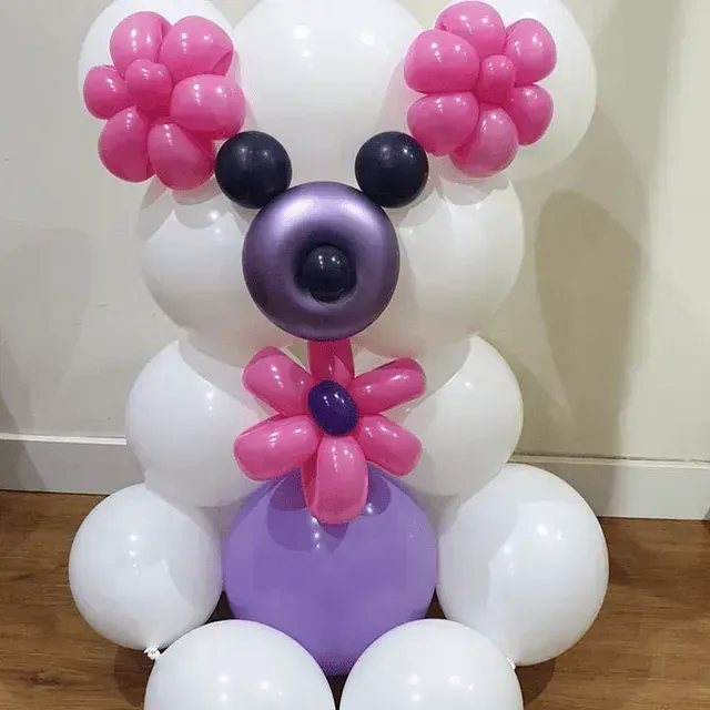 Un osito de peluche hecho con globos rosas y morados.
