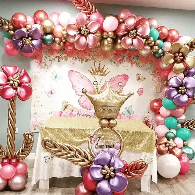 Una mesa está decorada con globos y una corona.