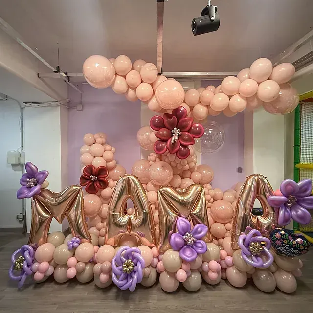 Una habitación llena de muchos globos y flores.