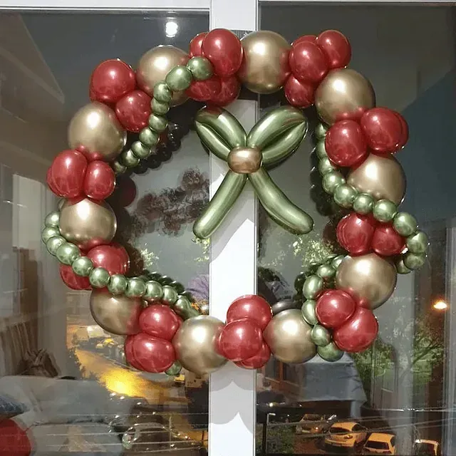 Una corona navideña hecha de globos rojos, dorados y verdes.