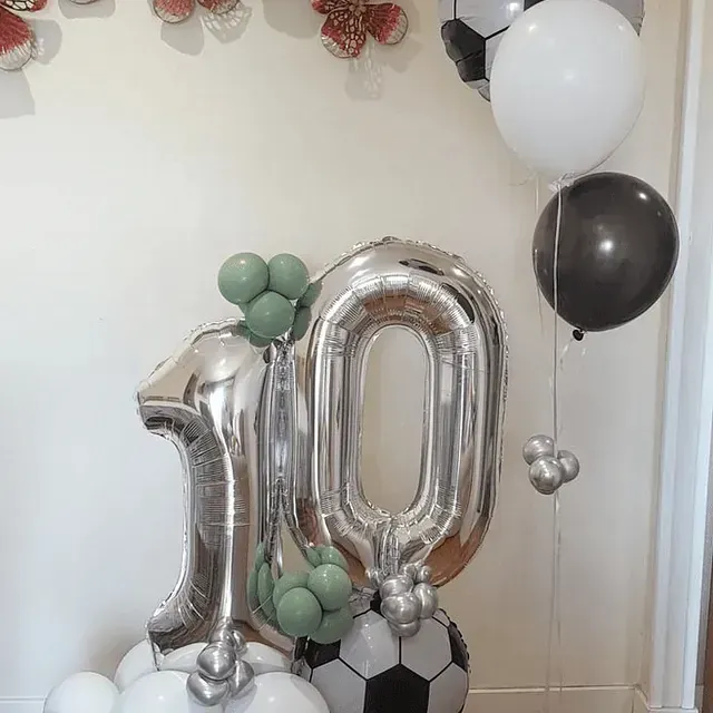 El número 10 está rodeado de globos y un balón de fútbol.