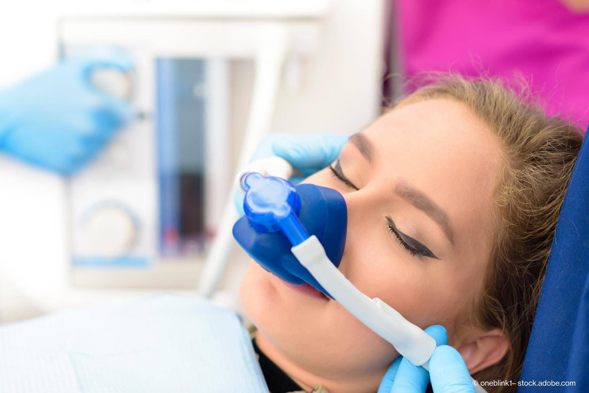 Eine Frau sitzt beim Arzt zur Kontrolle Eine entspannte Patientin erhält eine gründliche professionelle Zahnreinigung.