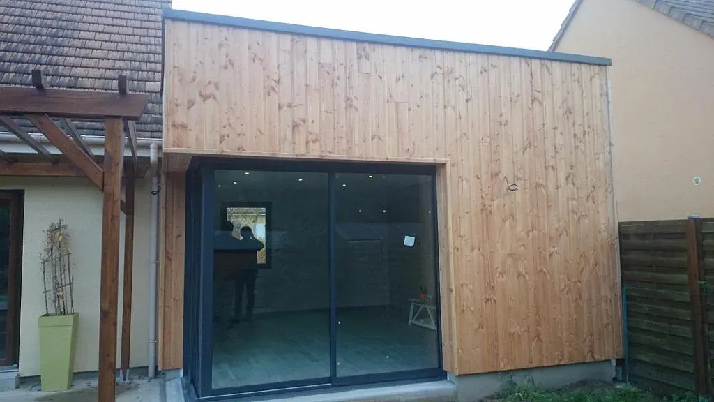 Extension de maison avec baie vitrée recouvert d'ossature en bois