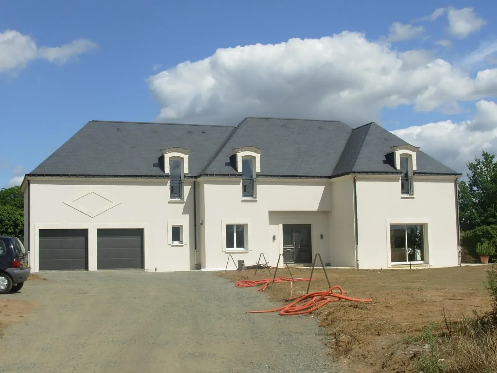 Maison de couleur blanche avec des tuiles en ardoise