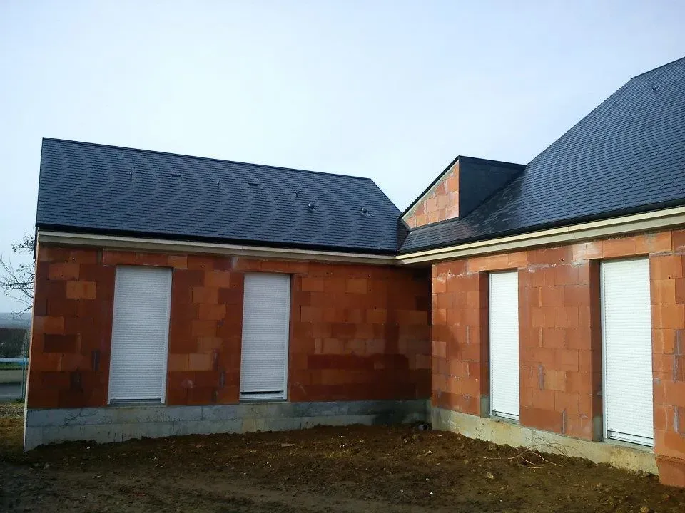 Maison en brique rouge avec des tuiles en ardoise