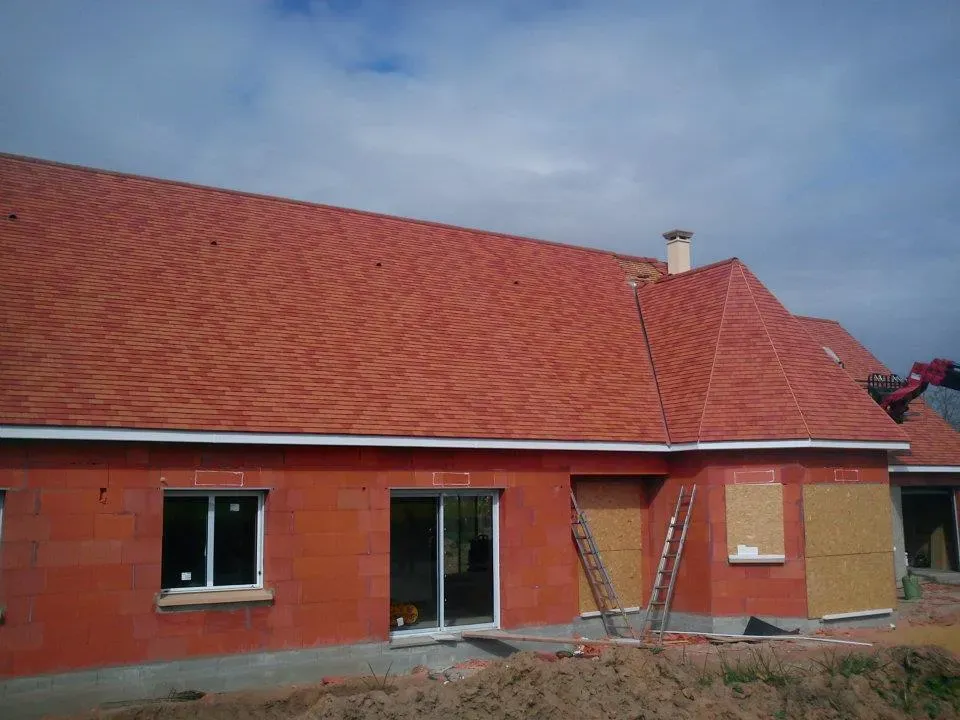 Maison beige avec toiture en ardoises