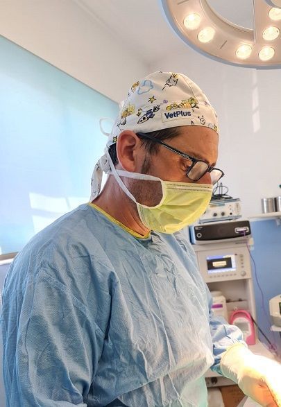 Un cirujano que lleva una máscara y un gorro está operando en un quirófano.