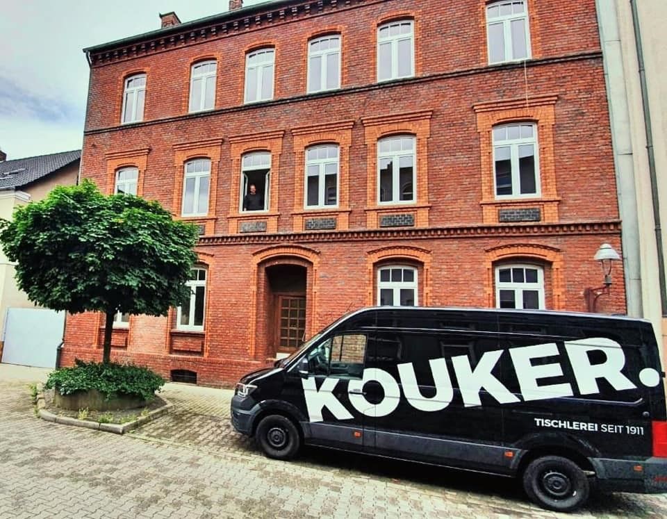 Ein Kouker-Van steht vor einem Backsteingebäude