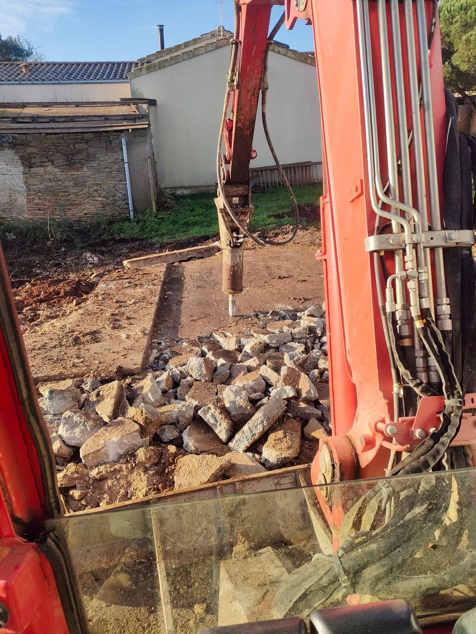 Un conteneur blanc rempli de déchets verts est stationné sur une allée de gravier devant un bâtiment blanc et bleu.