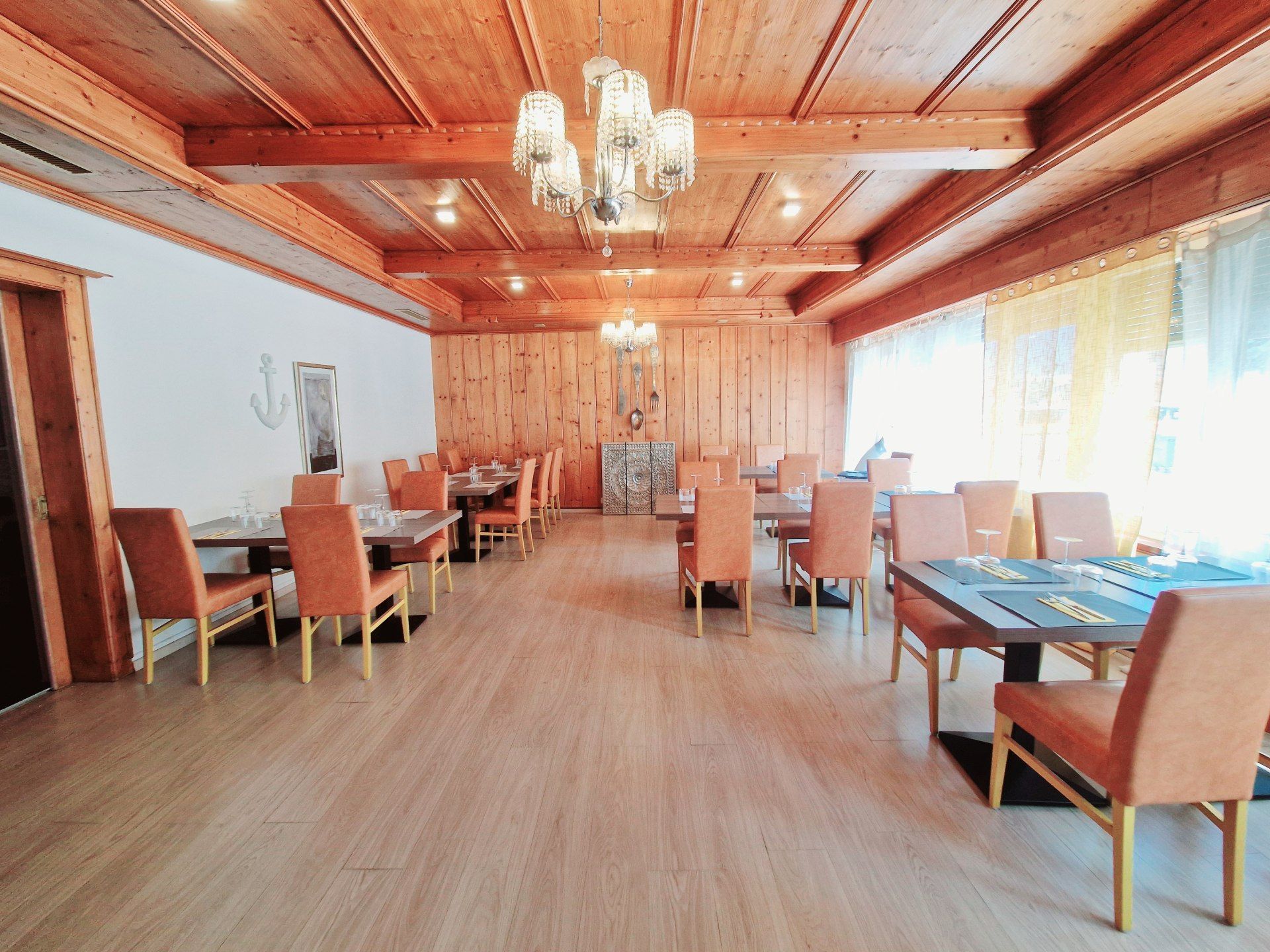 Une grande salle à manger avec tables et chaises et un plafond en bois.