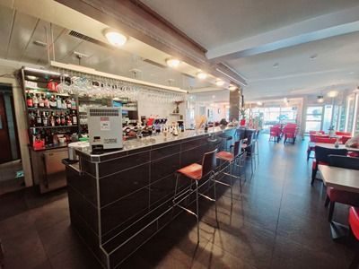 Un restaurant avec un long bar et des tables et des chaises.