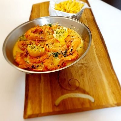 Un bol de crevettes est posé sur une planche à découper en bois