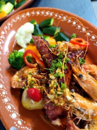 Un gros plan d'une assiette de nourriture avec des crevettes et des légumes