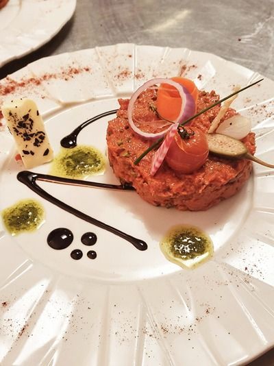 Une assiette blanche garnie d'une tomate et d'oignons