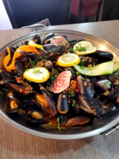 Une poêle remplie de moules et de légumes sur une table