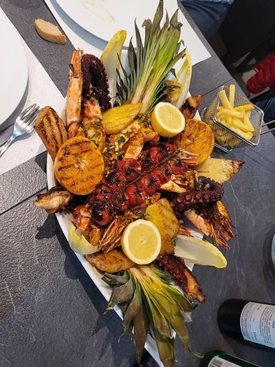 Une assiette de nourriture avec des citrons et des frites sur une table