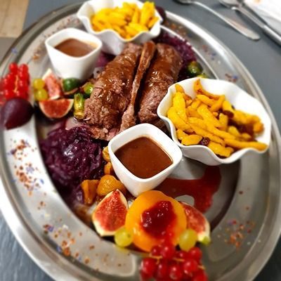 Une assiette de nourriture avec des sauces et des fruits sur une table