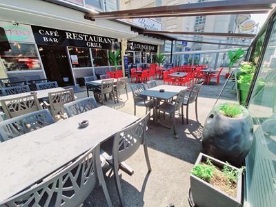 Un restaurant avec des tables et des chaises à l'extérieur par une journée ensoleillée