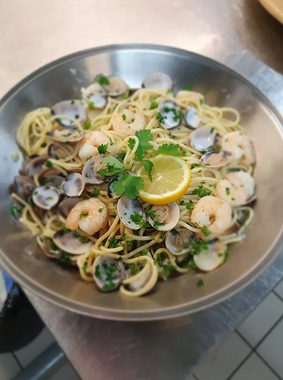 Un bol de spaghetti aux palourdes et aux crevettes sur une table