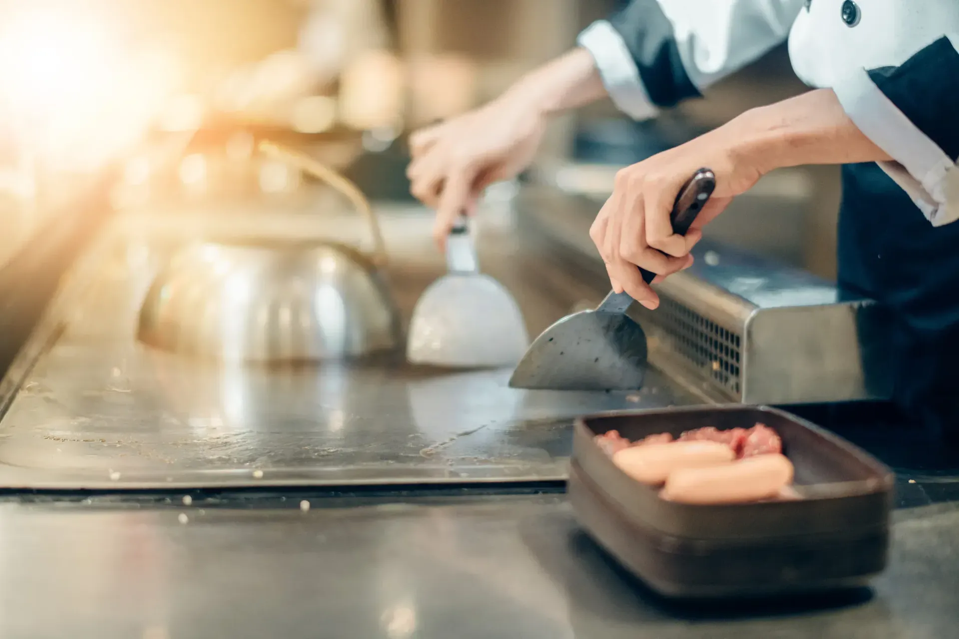 Un chef está cocinando comida en una estufa en una cocina.