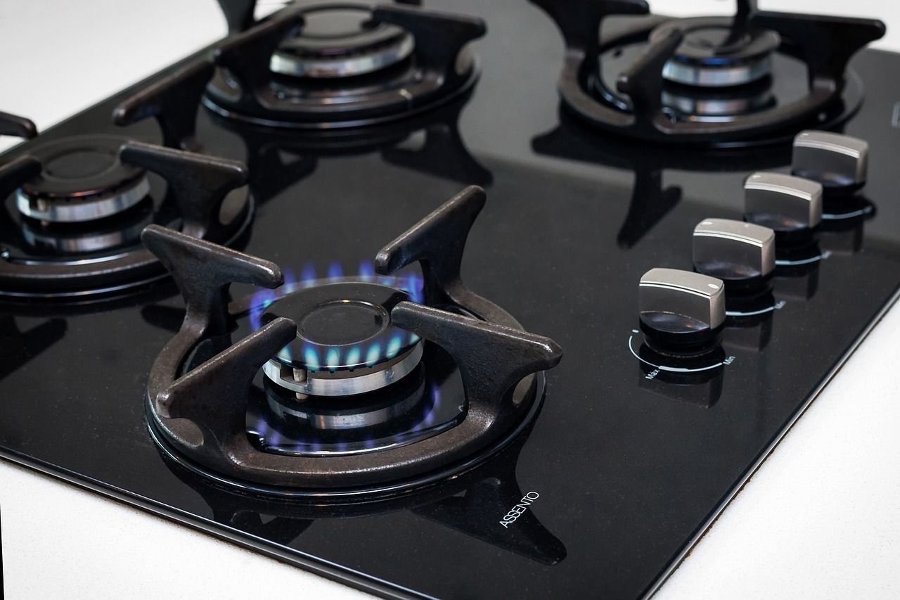 Una estufa de gas con cuatro quemadores y una llama azul