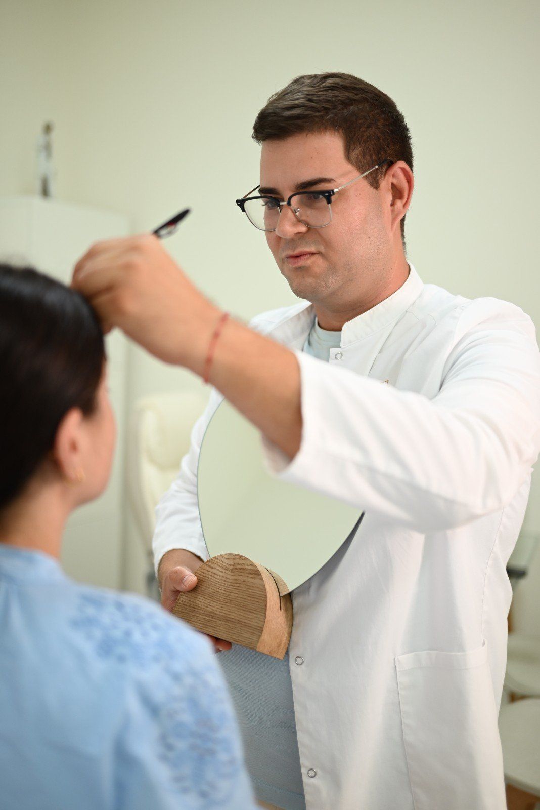 Médico examinando a un paciente con un instrumento de mano en una sala de consulta
