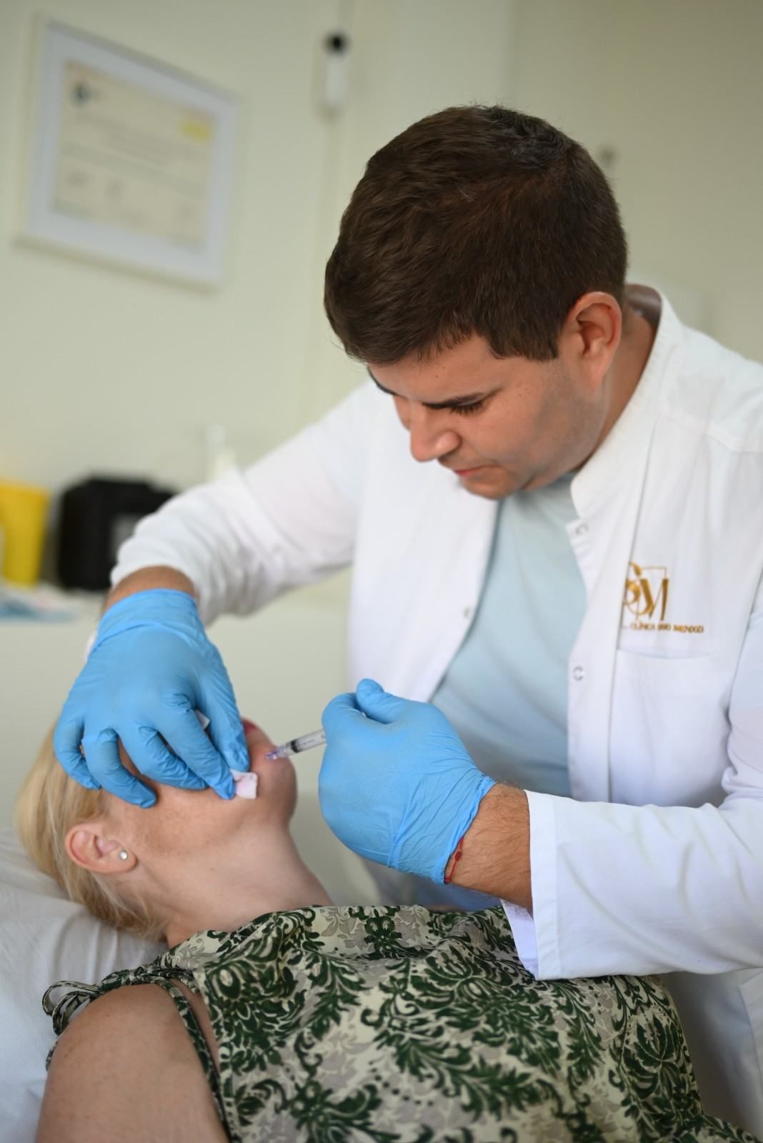 Primer plano de unos labios rosas brillantes, con los dientes blancos a la vista y la textura de la piel