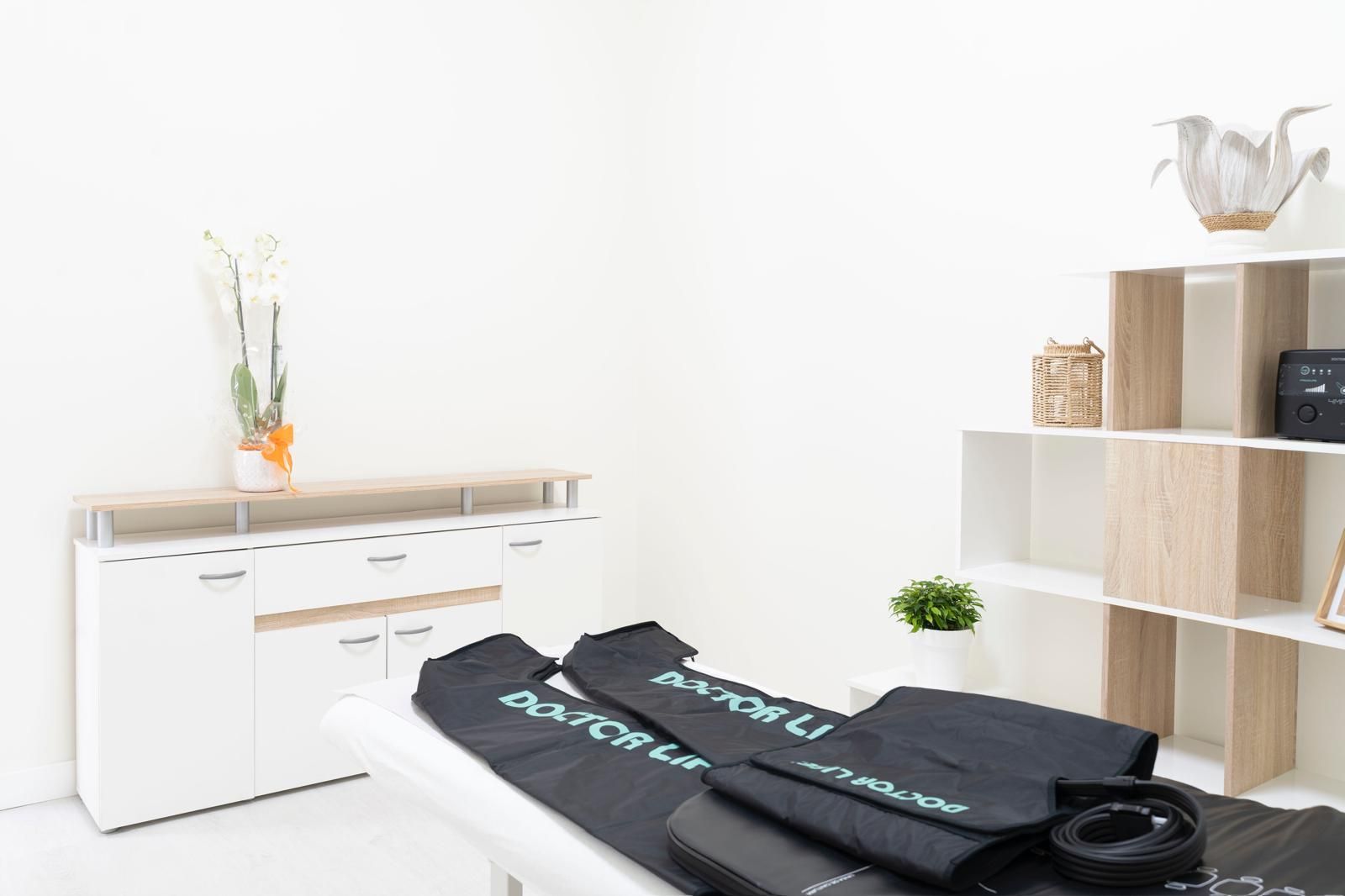 Habitación luminosa y minimalista, con escritorio blanco, estanterías y bolsos negros cuidadosamente ordenados sobre una cama o una mesa