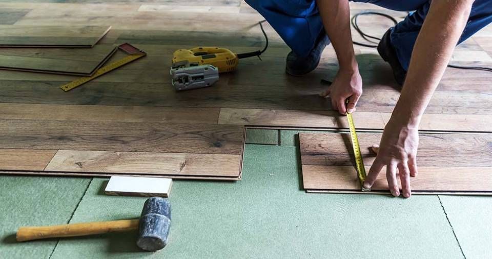 Mitarbeiter der Delen Bodenbeläge GmbH verlegt Laminat