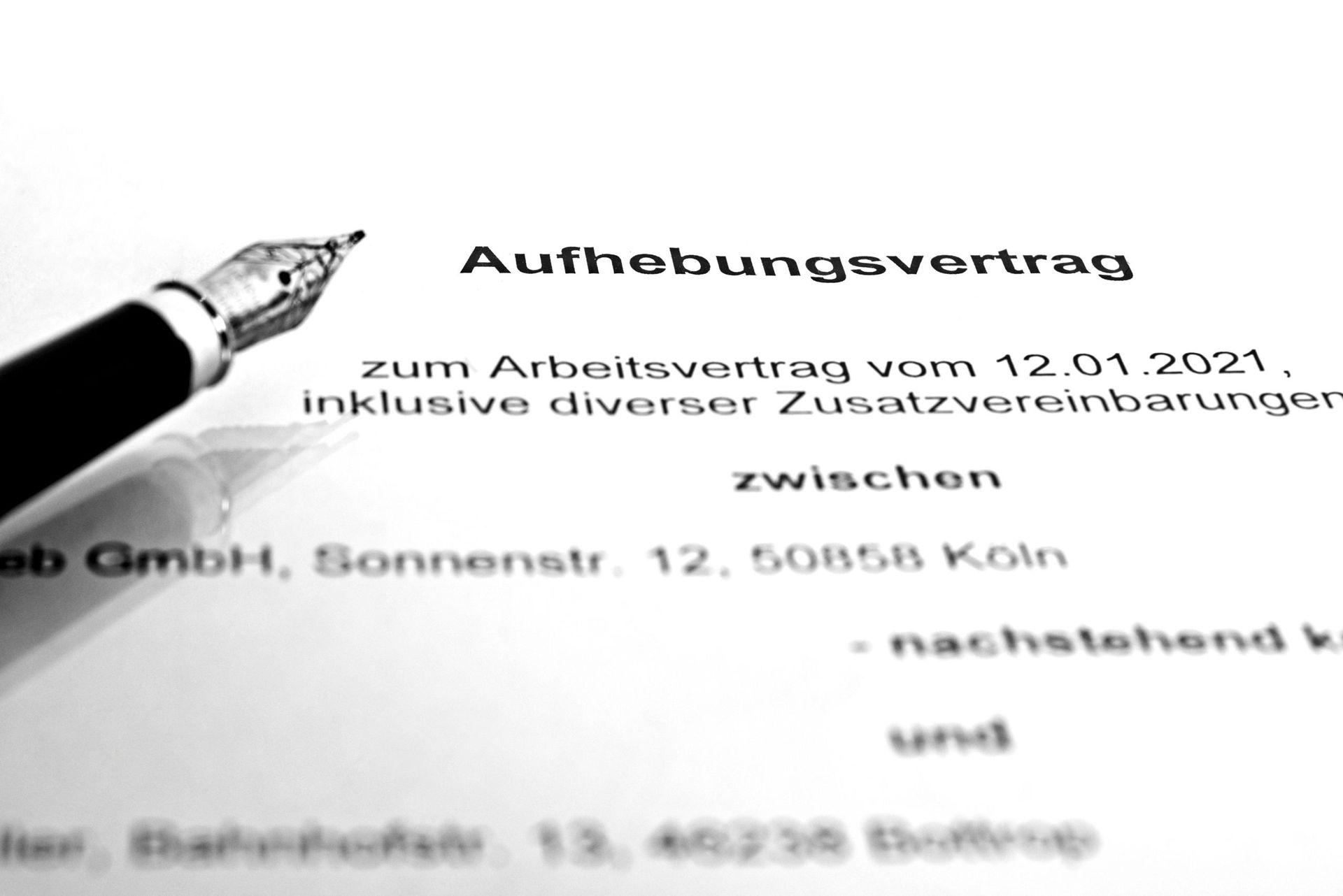 Nahaufnahme eines deutschen Aufhebungsvertrags, auf dessen Titel ein Stift auf einer weißen Seite zeigt.