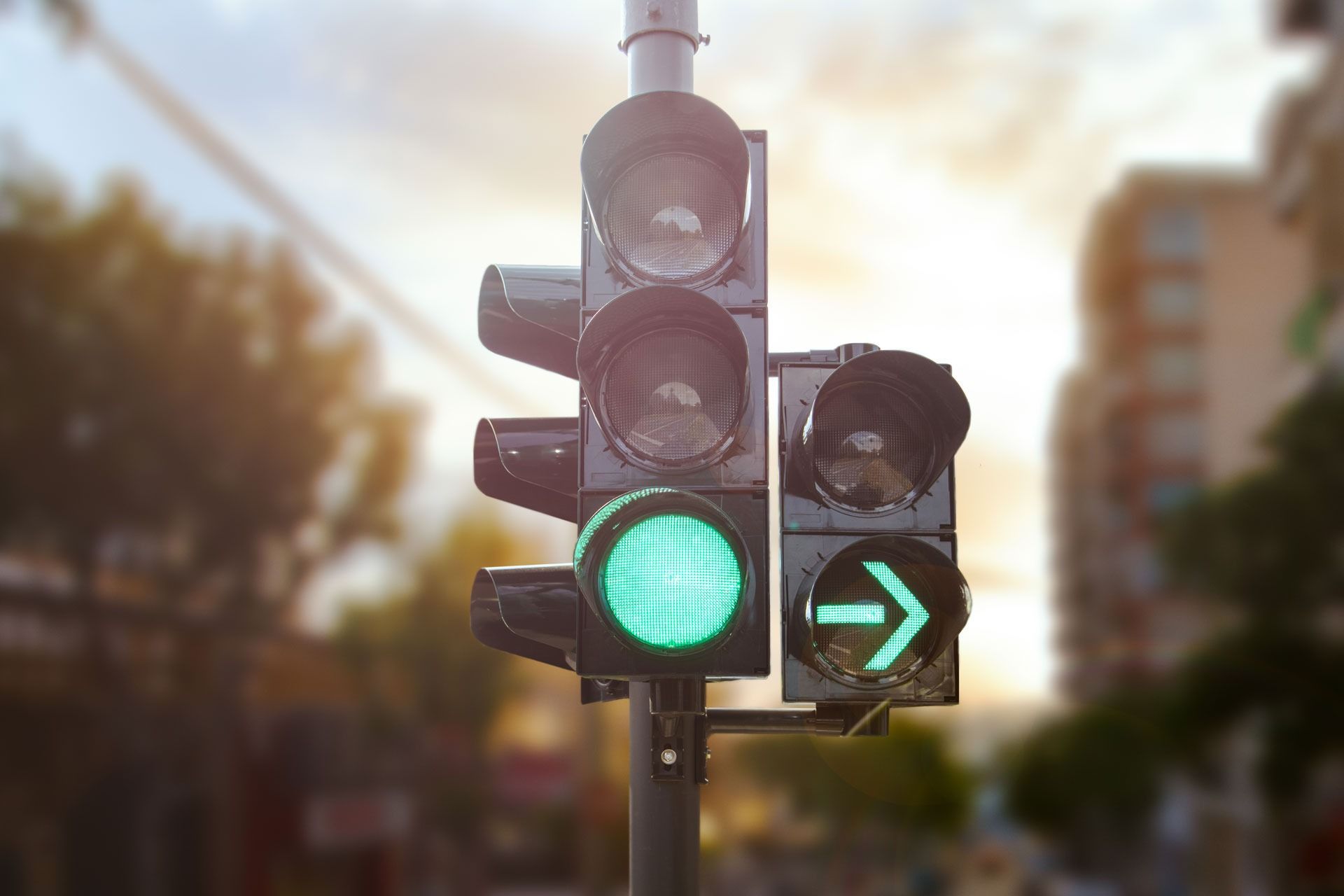 Grüne Ampel und Rechtsabbiegepfeil auf einer Stadtstraße in der Abenddämmerung