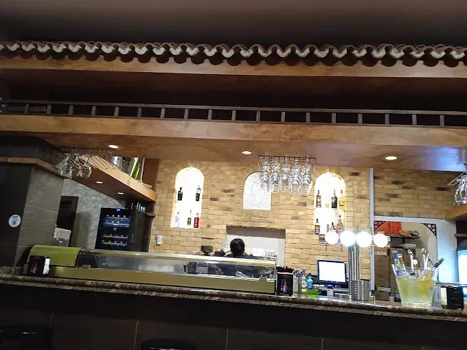 Un bar con una pared de ladrillo y un techo de madera.