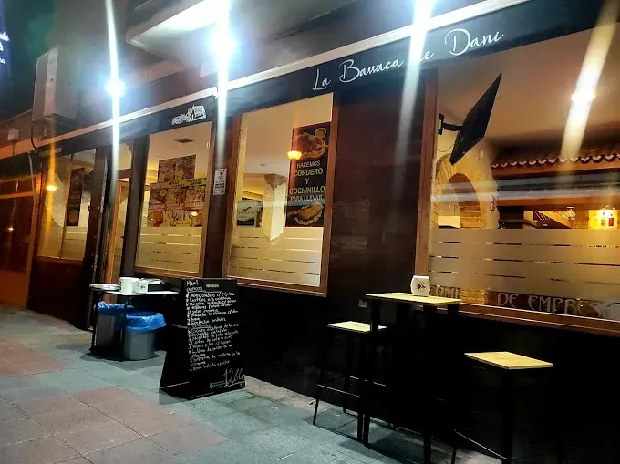 Un restaurante con mesas y sillas al aire libre por la noche.