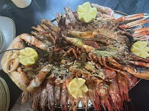 Un plato de mariscos con rodajas de limón sobre una mesa.