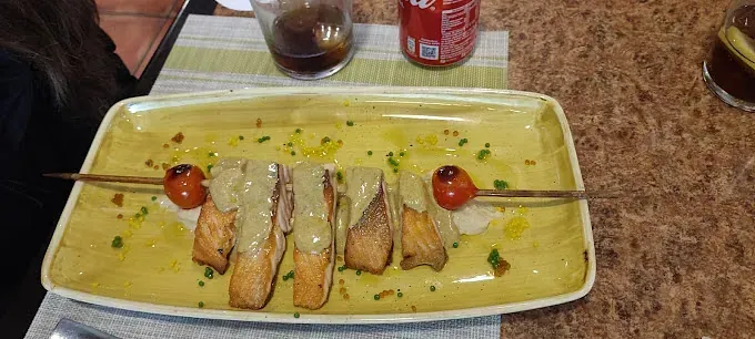 Un plato de comida está sobre una mesa al lado de una lata de Coca Cola.