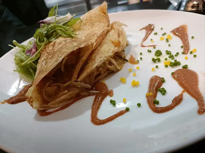 Un primer plano de un plato de comida con salsa encima.