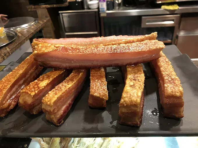 Una bandeja de tocino frito está sobre una mesa.