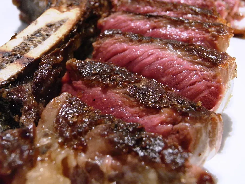 Un primer plano de un filete en un plato blanco.