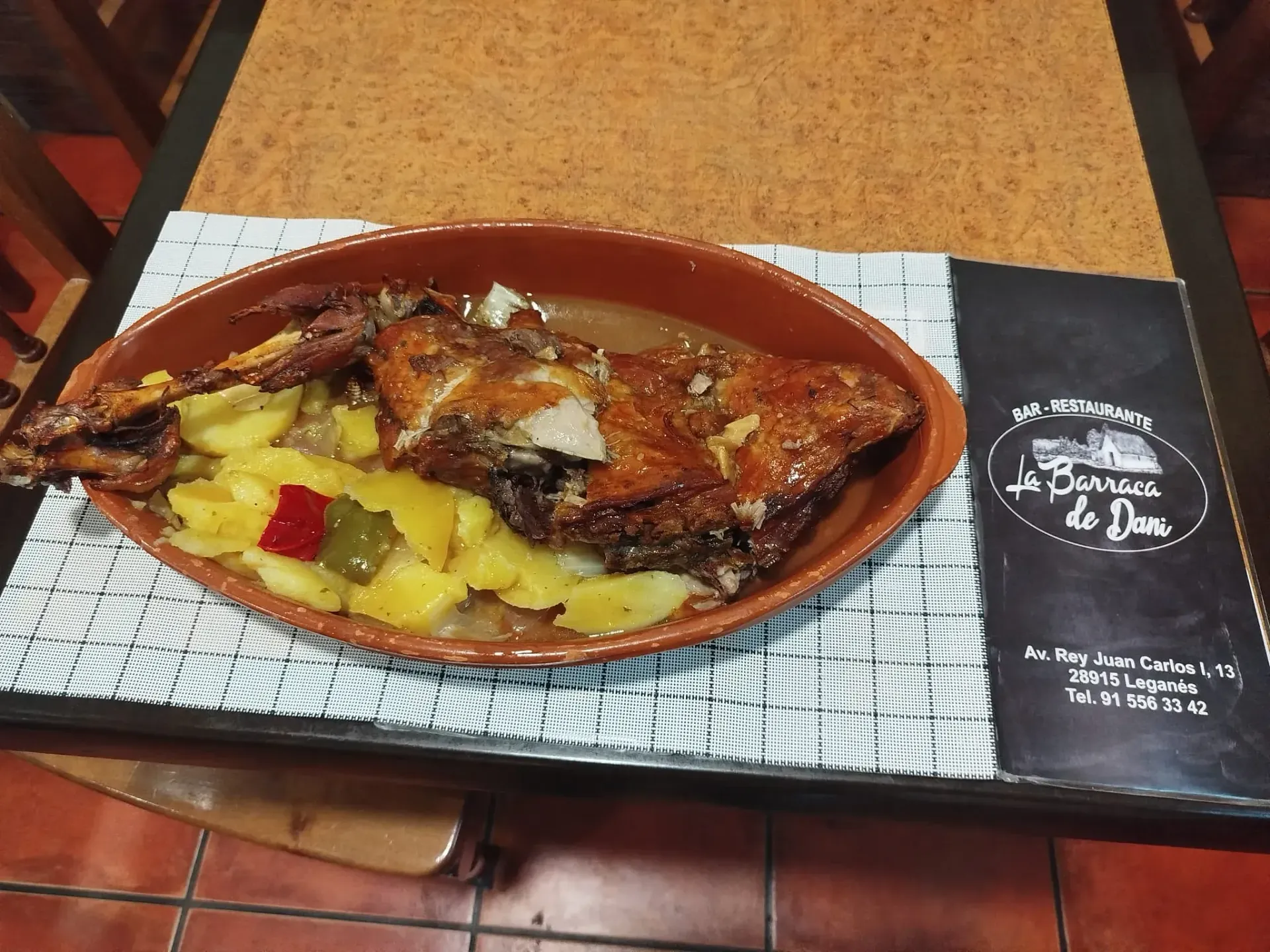 Un plato de comida con patatas y carne en una mesa.