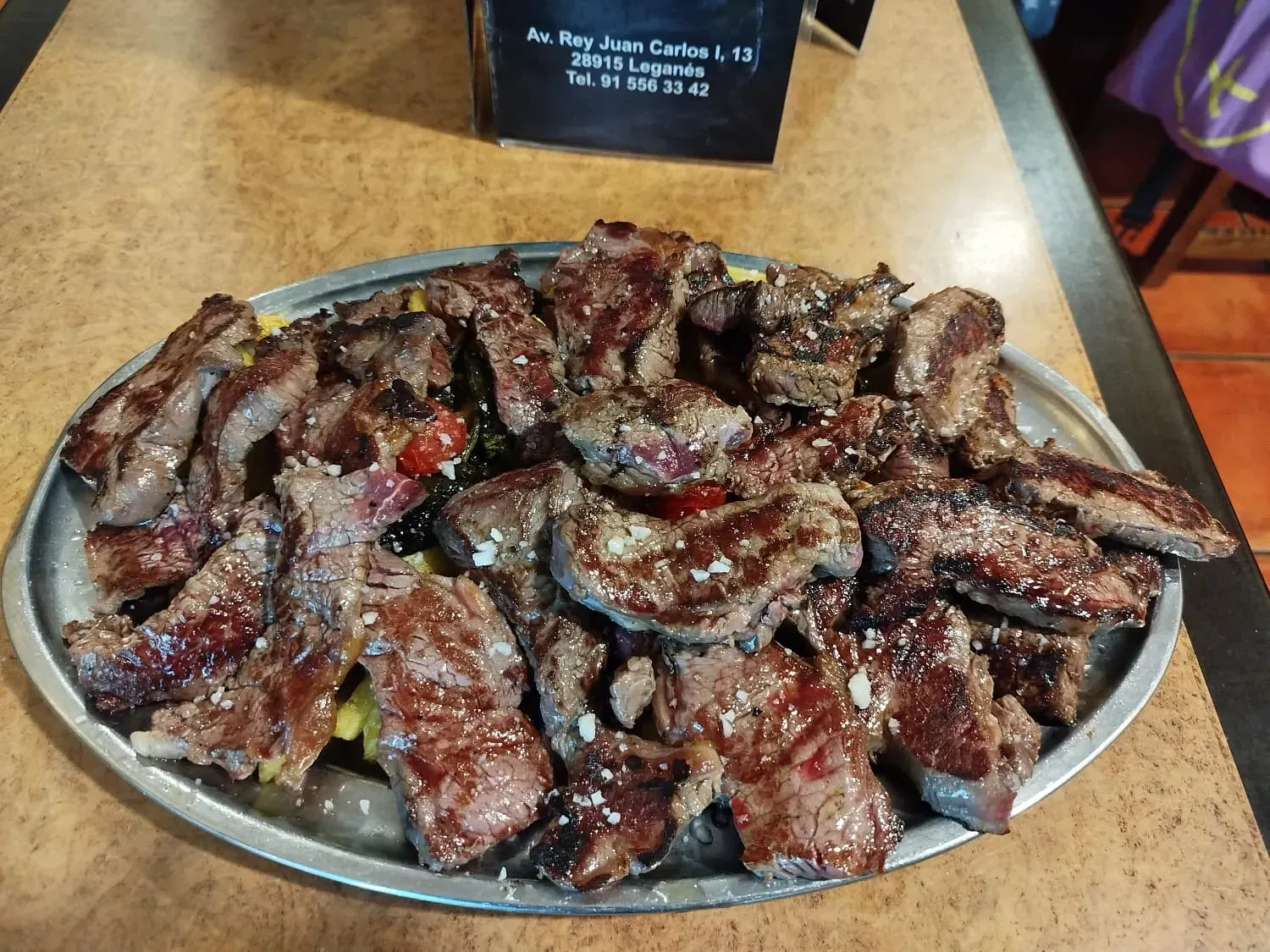 Un plato de carne y verduras está sobre una mesa.
