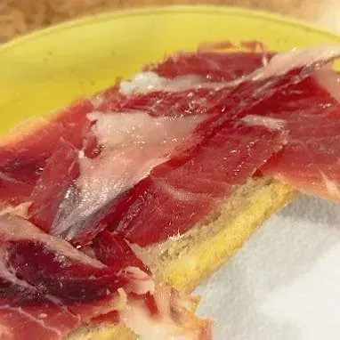 Un primer plano de un trozo de carne en un plato amarillo.