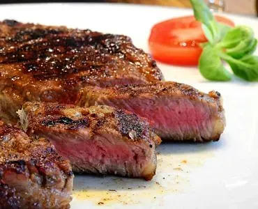 Un primer plano de un filete en un plato blanco.